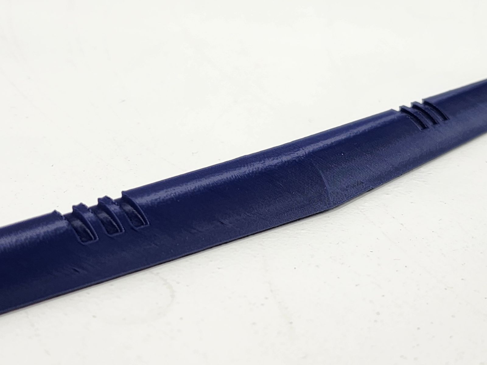 Blue printed dashboard trim piece with mounting tabs